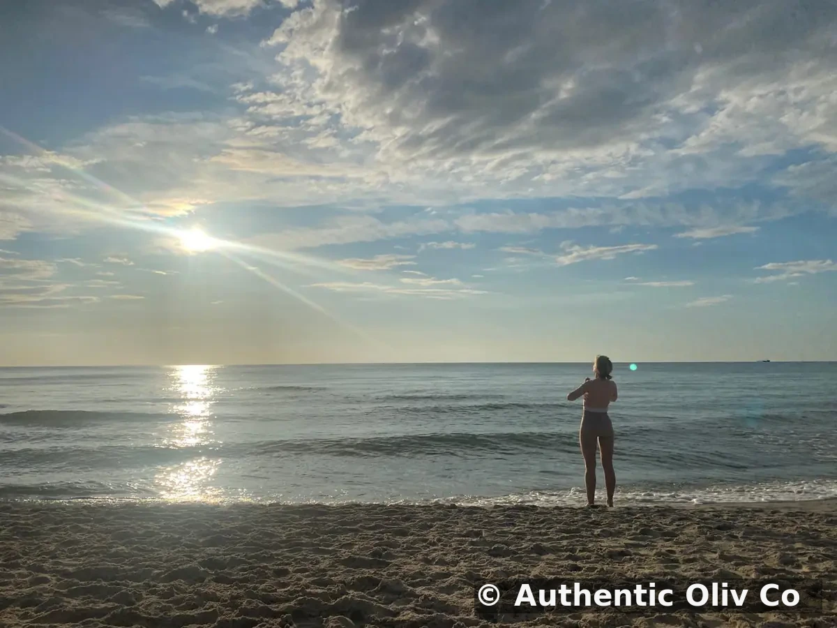 A woman exercising by the sea in Sardinia at sunset